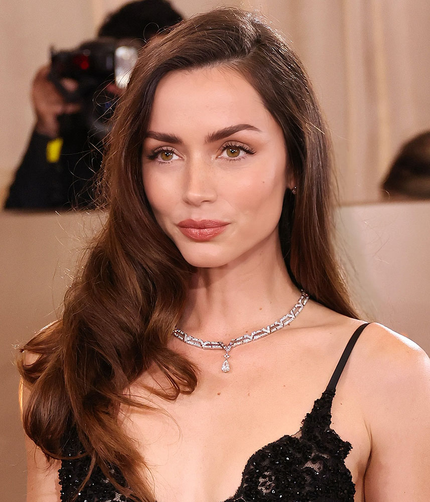 Ana de Armas with glossy side-parted waves creating a classic red carpet hairstyle at the Golden Globes.